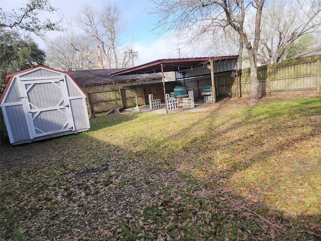 view of yard with a storage shed, an outbuilding, and a fenced backyard