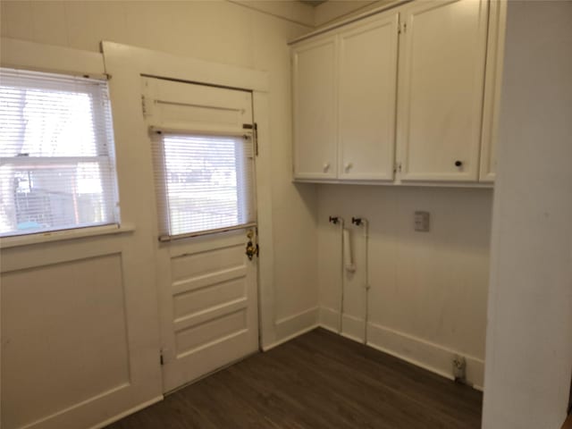 clothes washing area with baseboards and dark wood-style flooring