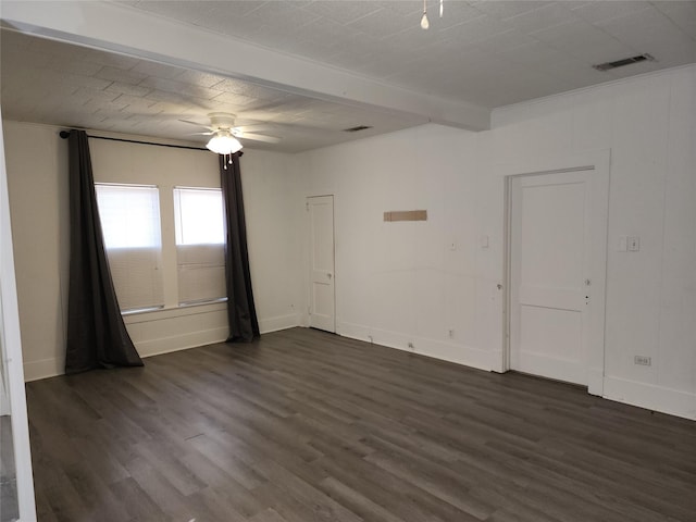 unfurnished room with baseboards, ceiling fan, visible vents, and dark wood-type flooring