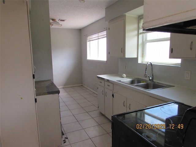 kitchen featuring black range with electric stovetop, white cabinets, a sink, and light countertops