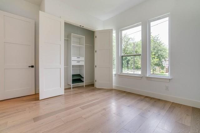 unfurnished bedroom featuring a closet, baseboards, and light wood-type flooring