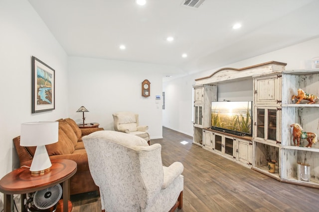 living room featuring baseboards, visible vents, wood finished floors, and recessed lighting