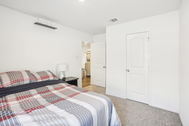 bedroom featuring visible vents and light colored carpet