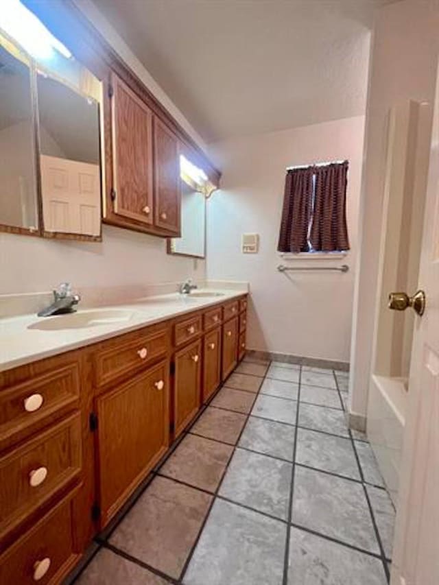 bathroom with tile patterned flooring, a sink, and double vanity