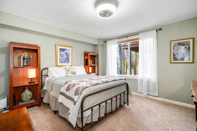 bedroom featuring carpet floors, baseboards, and a textured ceiling