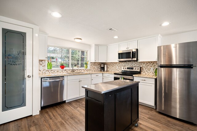 653 Terrace Trl, Goodrich, TX 77335 - kitchen with appliances with stainless steel finishes, dark wood finished floors, white cabinetry, and recessed lighting