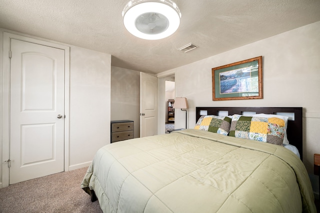 carpeted bedroom with visible vents and a textured ceiling