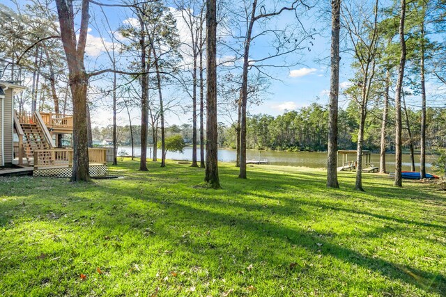 653 Terrace Trl, Goodrich, TX 77335 - view of grassy yard featuring stairway and a deck with water view