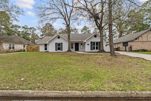 25511 Long Hill Ln, Spring, TX 77373 - view of front of home with fence, a front lawn, brick siding, and concrete driveway