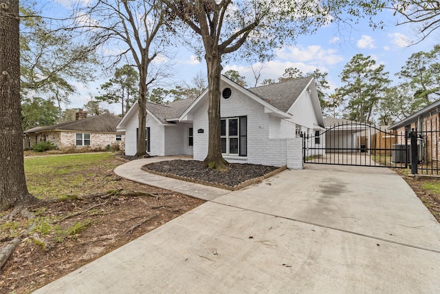 25511 Long Hill Ln, Spring, TX 77373 - view of front facade with a gate, fence, roof with shingles, concrete driveway, and brick siding