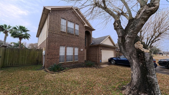 view of front of house with a front lawn, brick siding, fence, and an attached garage