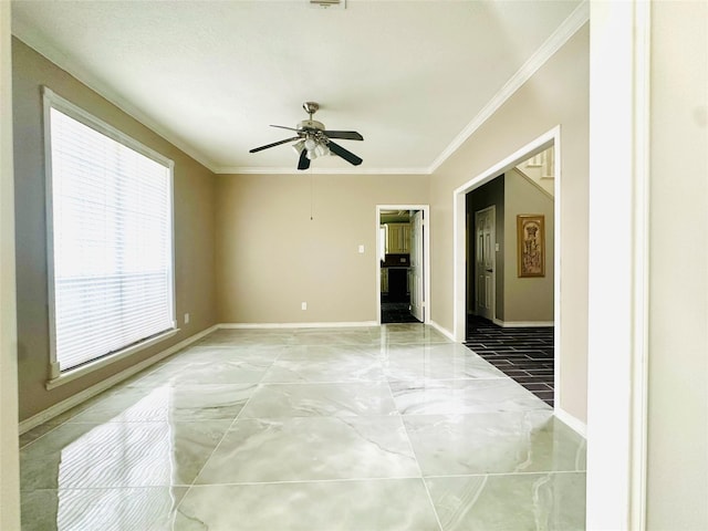 empty room with ornamental molding, marble finish floor, baseboards, and a ceiling fan