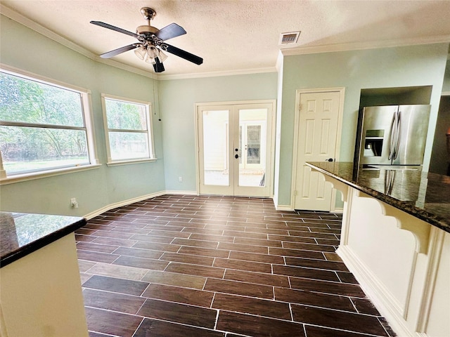 interior space with visible vents, french doors, wood tiled floor, a textured ceiling, and crown molding