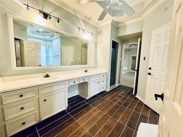 full bathroom featuring ceiling fan, double vanity, ornamental molding, and a sink