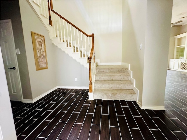 staircase featuring wood tiled floor and baseboards