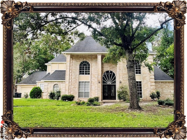 view of front of property featuring brick siding, roof with shingles, french doors, and a front yard