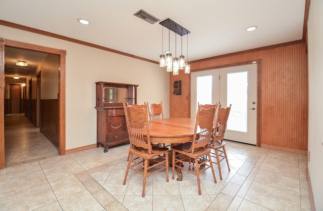 dining room with baseboards, light tile patterned flooring, visible vents, and crown molding