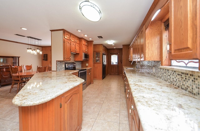 kitchen with light tile patterned floors, decorative backsplash, appliances with stainless steel finishes, brown cabinetry, and a sink