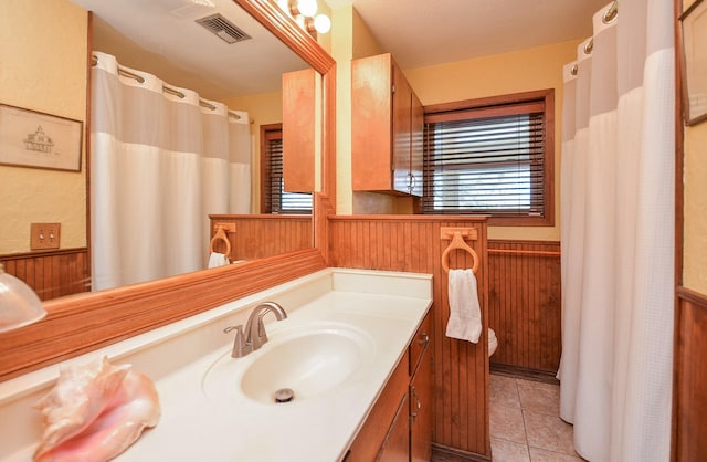 bathroom featuring visible vents, toilet, wainscoting, wooden walls, and tile patterned flooring