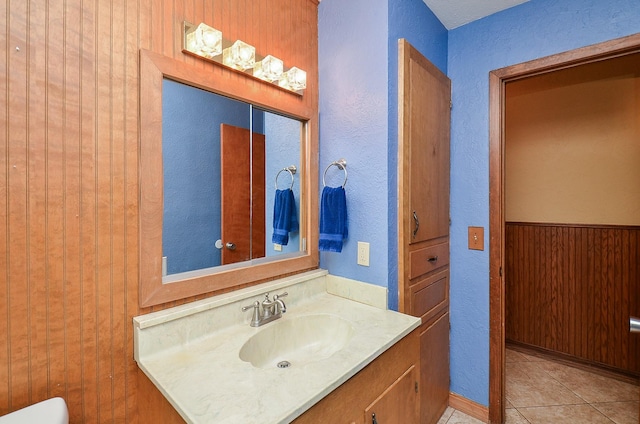 bathroom with a textured wall, vanity, and tile patterned floors