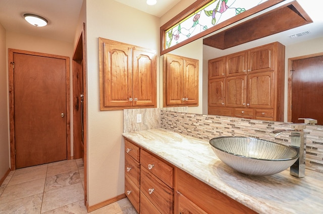 bathroom with tasteful backsplash, visible vents, baseboards, and vanity