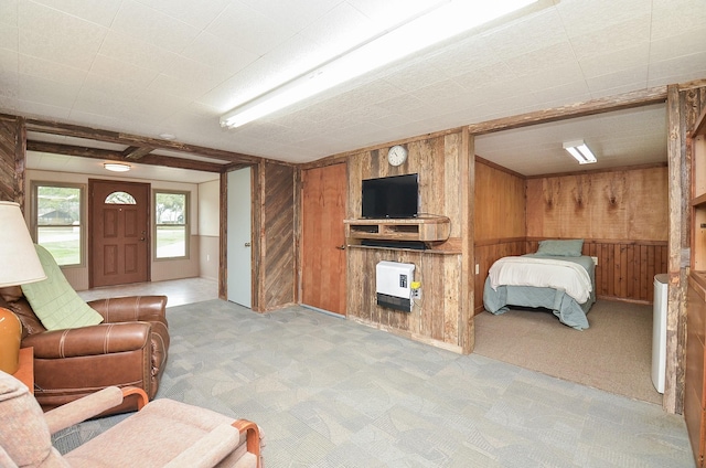 bedroom featuring light carpet, wood walls, and heating unit