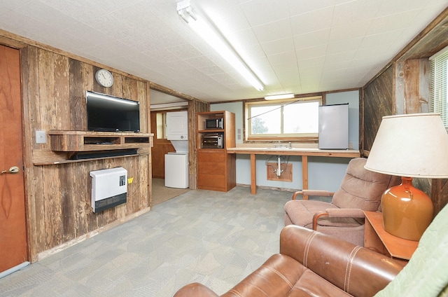 living room featuring heating unit, wooden walls, and light carpet