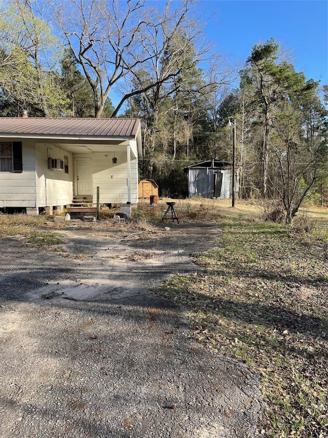 exterior space with driveway, a shed, and an outdoor structure