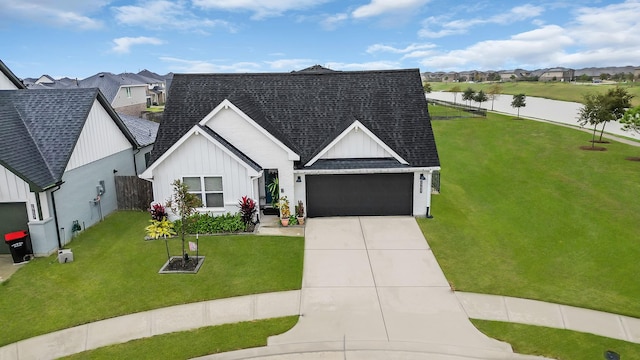 view of front of home with board and batten siding, concrete driveway, a front yard, a shingled roof, and a garage