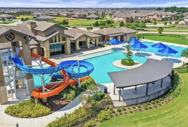 pool featuring a residential view, a water slide, and a water play area