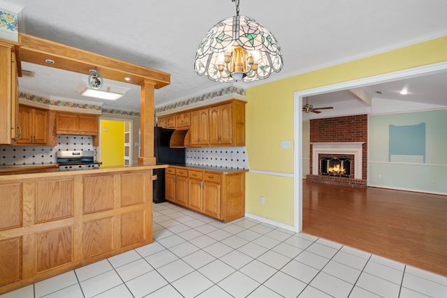 kitchen with light tile patterned floors, open floor plan, hanging light fixtures, light countertops, and stainless steel range with electric stovetop