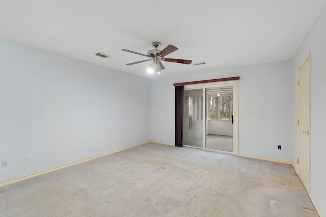 empty room featuring ceiling fan, visible vents, baseboards, and light colored carpet