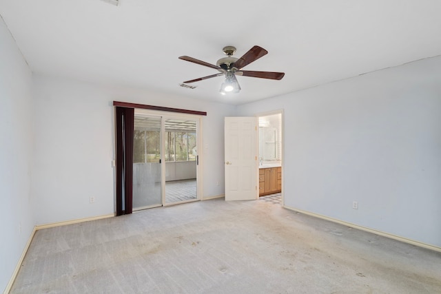 unfurnished bedroom with light carpet, baseboards, a ceiling fan, ensuite bath, and access to outside
