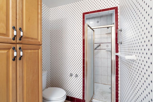 full bathroom featuring a shower stall, toilet, and tile walls