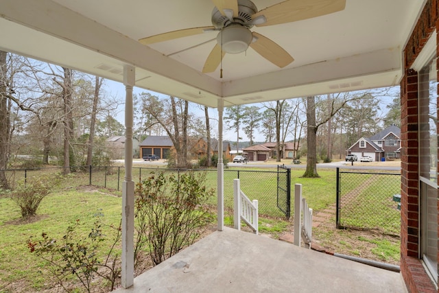 sunroom / solarium featuring a residential view and a ceiling fan