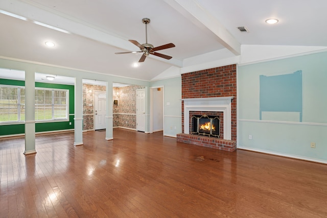 unfurnished living room featuring vaulted ceiling with beams, a fireplace, visible vents, wood finished floors, and baseboards