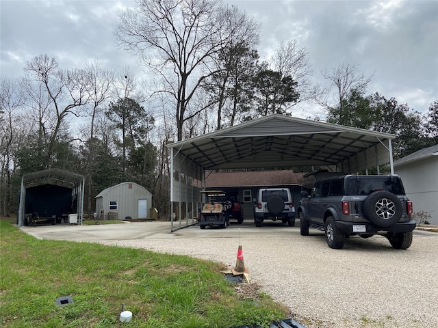 view of car parking featuring driveway, a storage unit, and a detached carport