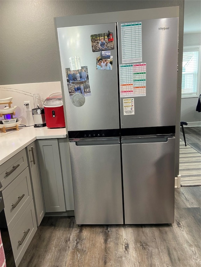 kitchen featuring light countertops, dark wood-style flooring, freestanding refrigerator, and gray cabinetry