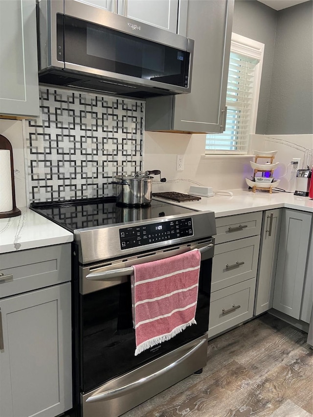 kitchen with appliances with stainless steel finishes, light countertops, and gray cabinetry