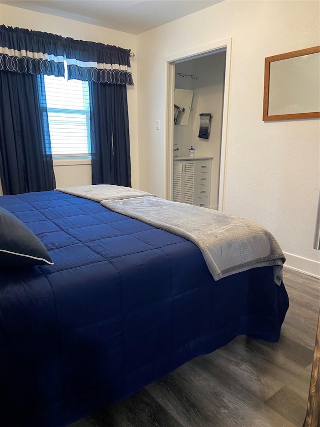 bedroom with baseboards and dark wood-style flooring