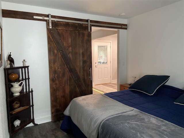 bedroom featuring a barn door and wood finished floors