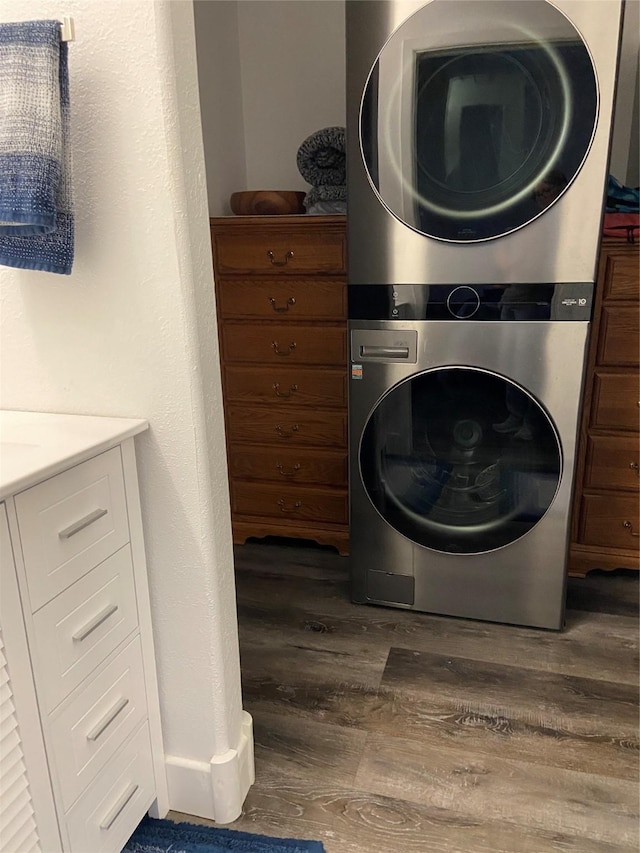 washroom with laundry area, dark wood finished floors, and stacked washing maching and dryer