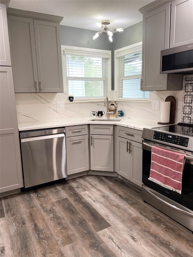 kitchen featuring stainless steel appliances, a sink, and gray cabinetry