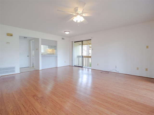 spare room with light wood-style flooring, visible vents, and a ceiling fan