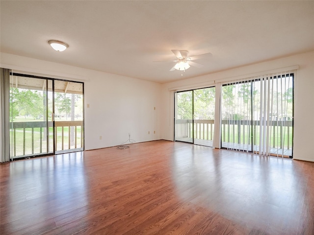 unfurnished room featuring plenty of natural light, a ceiling fan, and wood finished floors