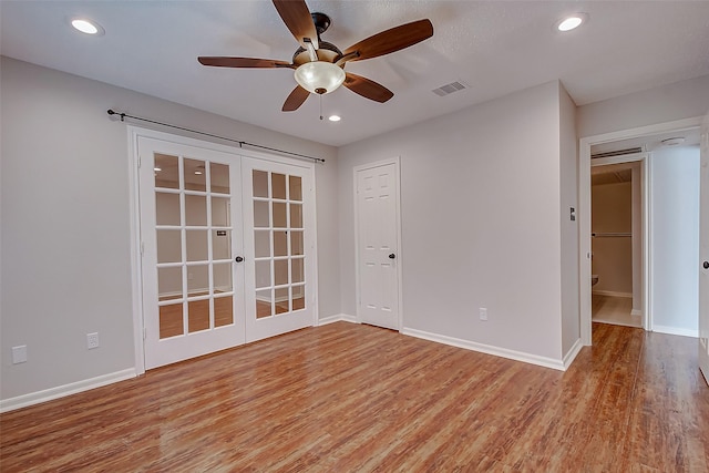 empty room featuring french doors, light wood finished floors, recessed lighting, visible vents, and baseboards