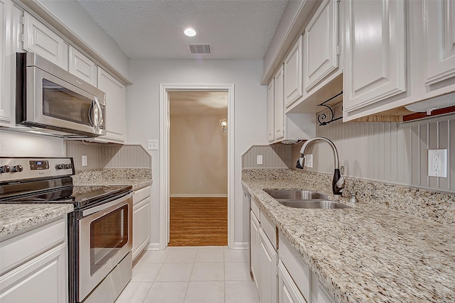 kitchen with visible vents, white cabinets, appliances with stainless steel finishes, a textured ceiling, and a sink