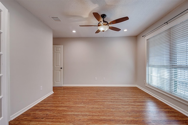 unfurnished room featuring baseboards, a ceiling fan, visible vents, and light wood-style floors