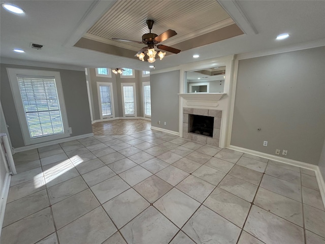 unfurnished living room featuring crown molding, light tile patterned floors, a raised ceiling, visible vents, and a tiled fireplace