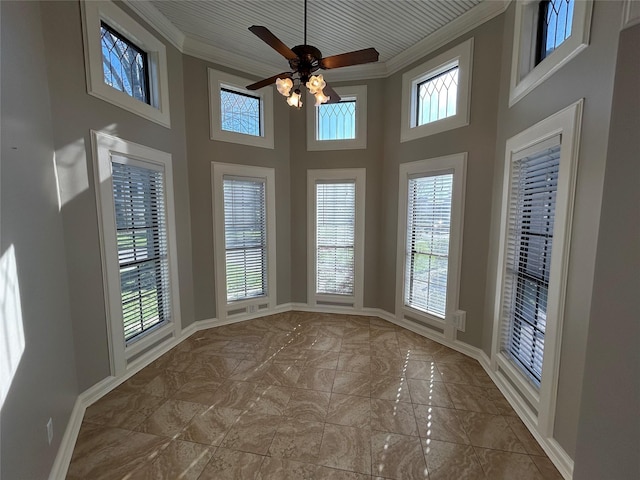 unfurnished sunroom featuring a ceiling fan